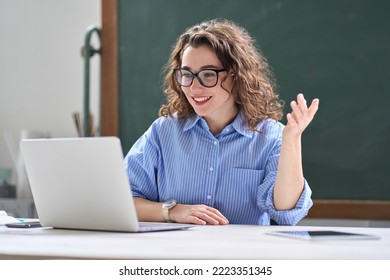 Young happy professional business woman online teacher or tutor sitting at work desk talking to student on video call teaching remote class, leading webinar or distance web meeting on laptop computer. - Powered by Shutterstock