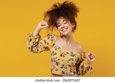 Junge glücklich entspannte schöne kaukasische Frau 20er mit scharfem Haar in ungezwungenen Kleidung Tanz haben Spaß auf Party, enge Augen einzeln auf einfarbigem gelbem Hintergrund Studioportrait People Lifestyle Konzept