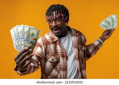 Young Happy Rich African Man In Casual Shirt Holding Dollar Bills Against Yellow Background