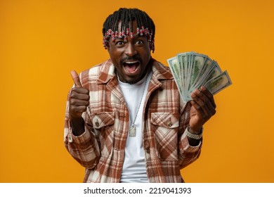 Young Happy Rich African Man In Casual Shirt Holding Dollar Bills Against Yellow Background