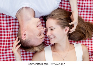 Young Happy Romantic Couple Cuddling On A Picnic Blanket Looking To Each Other, Top View