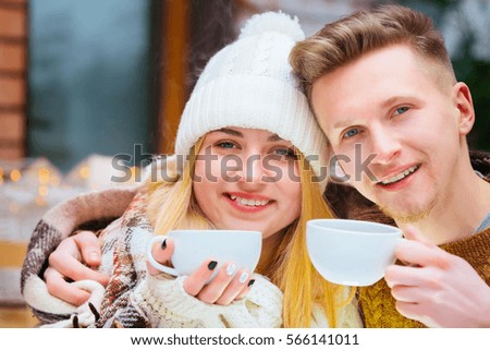 Young happy romantic couple sitting in cafe and holding hands