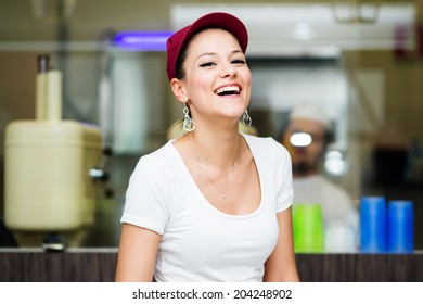 Young Happy Saleswoman Portrait Inside Ice Cream Shop. 