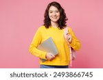 Young happy smart teen girl IT student she wear yellow casual clothes backpack bag hold closed laptop pc computer isolated on plain pastel light pink background. High school university college concept