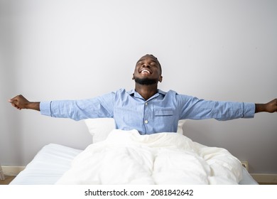 Young Happy Smiling African Man Waking Up At Bedroom