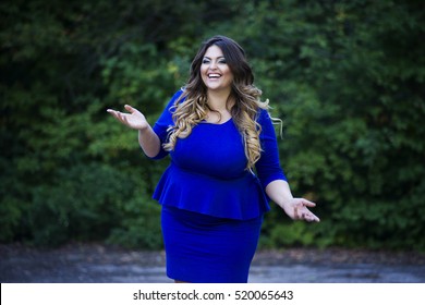 Young happy smiling beautiful plus size model in blue dress outdoors, xxl woman on nature, professional makeup and hairstyle