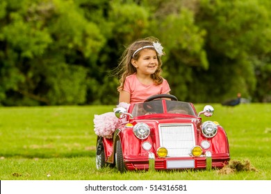 Young Happy Smiling Child Girl Driving Toy Car