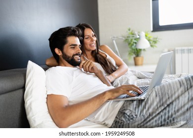 Young happy smiling couple with notebook at bedroom - Powered by Shutterstock