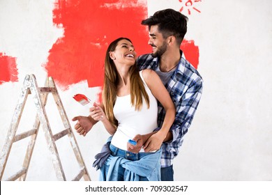 Young Happy Smiling Couple Painting Walls In Their New House