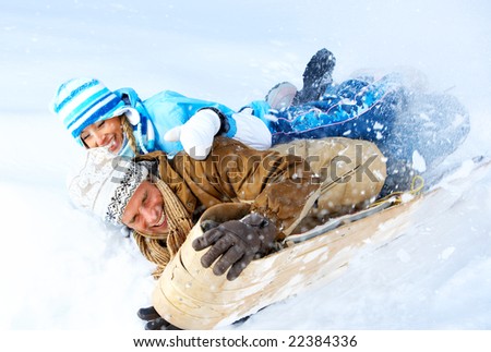 Young  happy smiling couple sledging. Winter