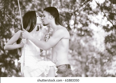 Young happy smiling embracing couple swinging outdoor in nature - Powered by Shutterstock