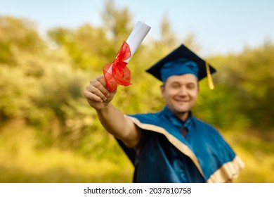 A Young Happy Smiling Man Celebrates His Degree And Phd Diploma. Celebrating Graduation Concept