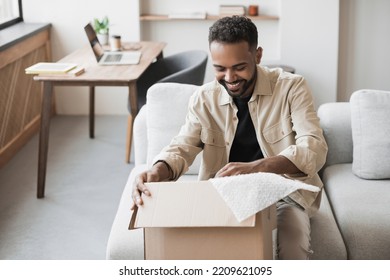 Young Happy Smiling Man Opening Parcel. Delivery, Shipping, Order Online, Home Shopping, Satisfied Customer Concepts