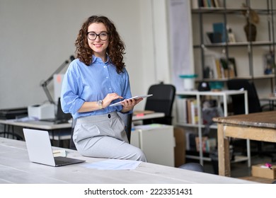 Young happy smiling professional business woman, female company worker or corporate manager holding digital tablet technology posing in modern office working, looking at camera, portrait. - Shutterstock ID 2223351431