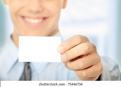 Young happy smiling successful business man with blank business card or sign - Powered by Shutterstock