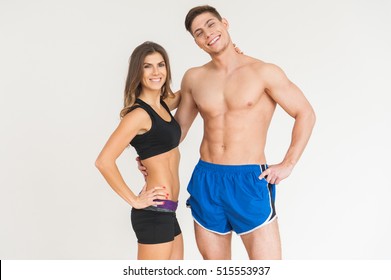 Young happy sportsmen couple woman and man in gym looking to the camera