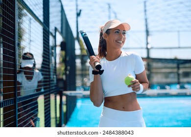 Young happy sportswoman playing paddle tennis and looking away. Copy space.  - Powered by Shutterstock