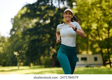 Young happy sportswoman running in the park. Copy space. - Powered by Shutterstock