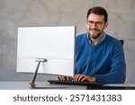 Young happy successful young businessman working and smiling at corporate office