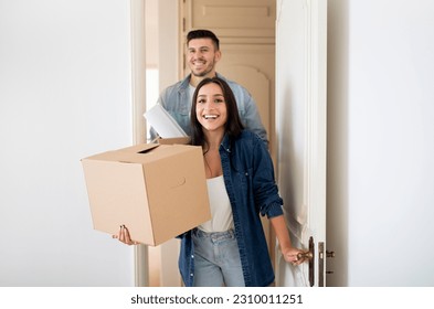 Young Happy Tenants Couple Entering Their New Home After Moving, Smiling European Spouses Opening Door And Carrying Boxes With Belingings, Excited Man And Woman Celebrating Relocation, Copy Space - Powered by Shutterstock