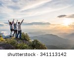 Young happy tourist on top of a mountain enjoying valley view before sunset.