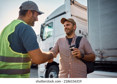 Young happy truck driver shaking hands with a dispatcher on parking lot. - Shutterstock ID 2186156319