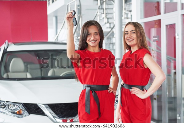 Young happy two woman near the car with keys in hand\
- concept of buying car