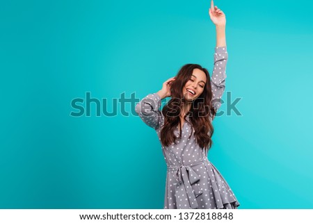 Young happy woman dancing and moving isolated over bright blue background
