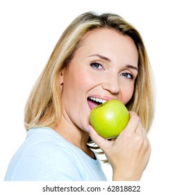Young happy woman eats green apple - on white background