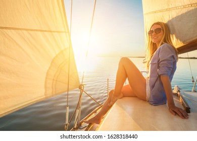 Young Happy Woman Enjoying Sunset From Deck Of Sailing Boat Moving In Sea At Evening Time. Travel, Summer, Holidays, Journey, Trip, Lifestyle, Yachting Concept.