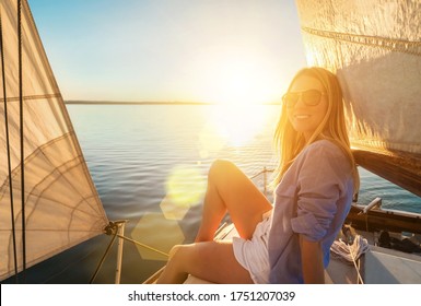 Young Happy Woman Enjoying Sunset From Deck Of Sailing Boat Moving In Sea At Evening Time. Travel, Summer, Holidays, Journey, Trip, Lifestyle, Yachting Concept.