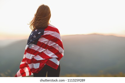 Young Happy Woman With Flag Of United States Enjoying The Sunset On Nature
