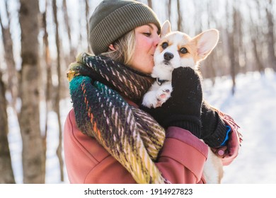 A Young Happy Woman Having Fun In Snowy Winter Park With Corgi Baby Dog