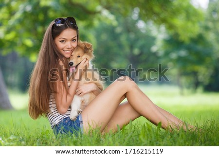 Young happy woman with her dog in park