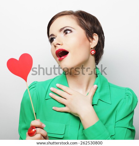 Young happy woman holding red  paper heart and ready for party 