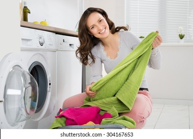 Young Happy Woman Laundering Clothes In Electronic Washer