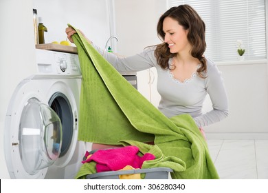 Young Happy Woman Laundering Clothes In Electronic Washer