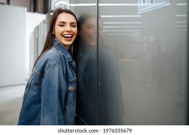 Young Happy Woman Leaning On Her New Refrigerator In A Mall