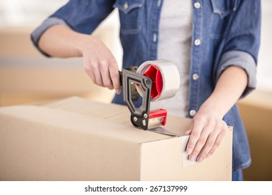 The young happy woman packing boxes. Moving, purchase of new habitation.