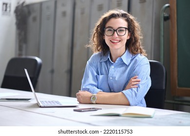 Young happy woman school professional online teacher or tutor sitting at desk with laptop computer, virtual distance classes for students, teaching remote education webinars concept. Portrait - Powered by Shutterstock