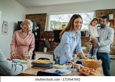 Young happy woman setting dining table for family lunch at home.  - Shutterstock ID 1719647692