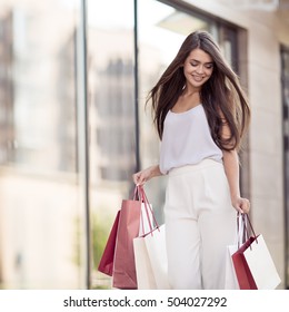 Young Happy Woman With Shopping Bags Walking On Street.