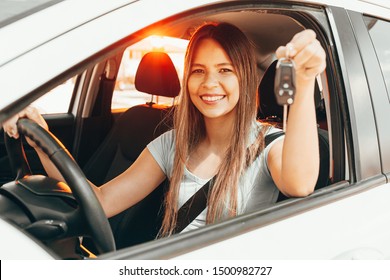 Young happy woman showing the key of new car - Shutterstock ID 1500982727