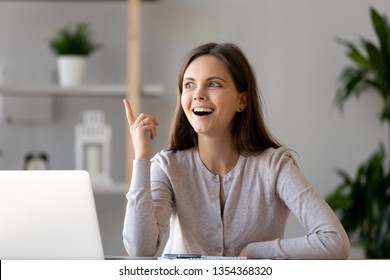 Young happy woman sitting at desk near laptop gesturing with hand make finger up, feels excited with good idea reach inspiration motivation, found solution for success at work or study, eureka concept - Shutterstock ID 1354368320