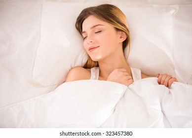 Young Happy Woman Sleeping In Bed At Home