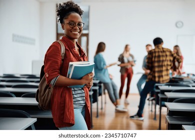 Young happy woman at university classroom looking at camera.