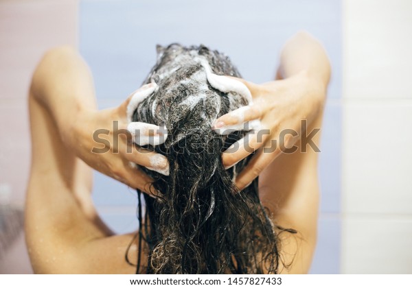 シャンプーで髪を洗う若い幸せな女性 泡を立てた手の接写 シャワーを浴びてリラックスした時間を楽しむ美しいブルネットの女の子の背景 身体と髪の衛生 ライフスタイルのコンセプト の写真素材 今すぐ編集 1457827433