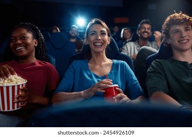 Young happy woman watching movie with her friends in cinema.  - Powered by Shutterstock