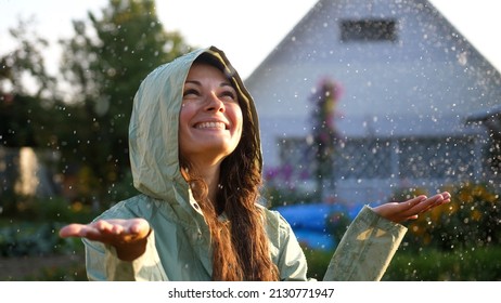 Young Happy Woman Wearing Green Raincoat Is Feeling Free And Smiling Under The Rain. Concept Of Life, Freedom, Nature, Adventure, Purity.