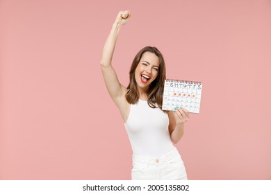 Young Happy Woman In White Clothes Hold Female Periods Calendar For Checking Menstruation Days Do Winner Gesture Scream Yes Isolated On Pastel Pink Background Medical Healthcare Gynecological Concept.